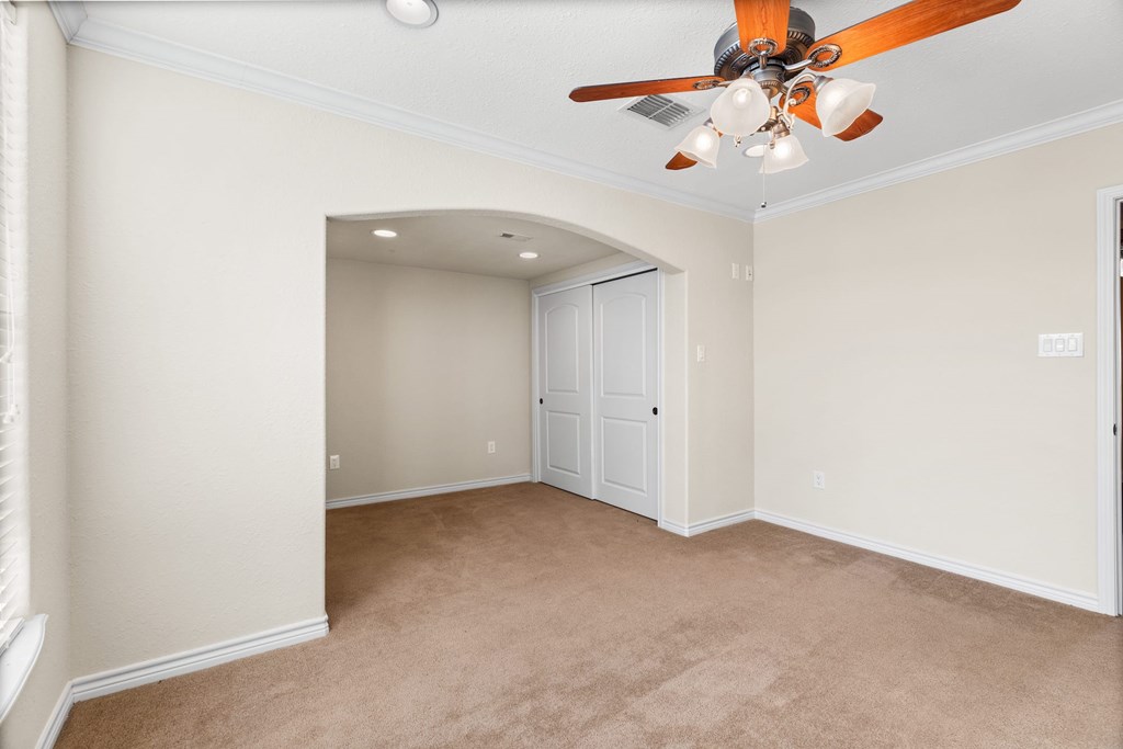 157 McCullough Ranch Road Kerrville, TX 78028 - Photo 50 of 75 an empty room with a chandelier fan and wooden floor