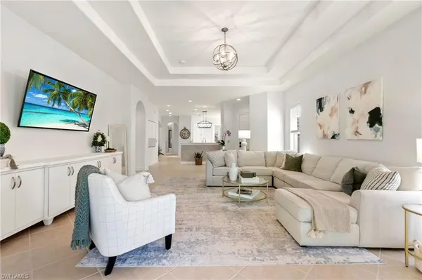 a living room with furniture a bed and a chandelier