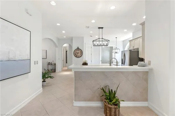 a view of a center kitchen island wooden floor and a living room view