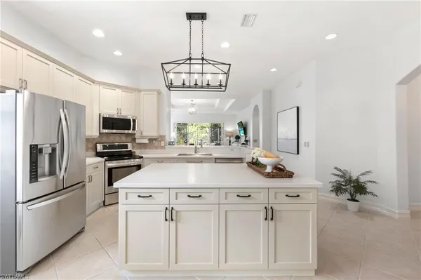 a kitchen that has a lot of cabinets in it and stainless steel appliances