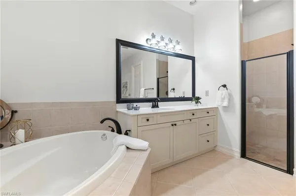 a bathroom with a double vanity sink mirror and bathtub