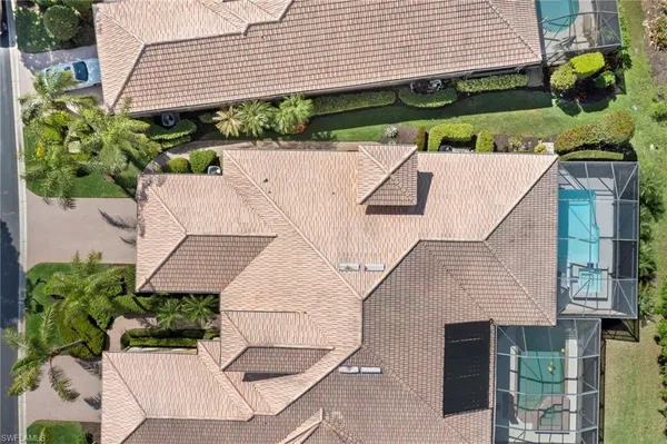 an aerial view of a house with a garden and lake view