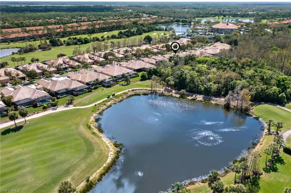 an aerial view of residential houses with outdoor space and lake view