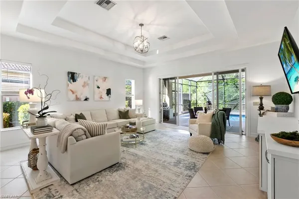a living room with furniture a chandelier and a large window