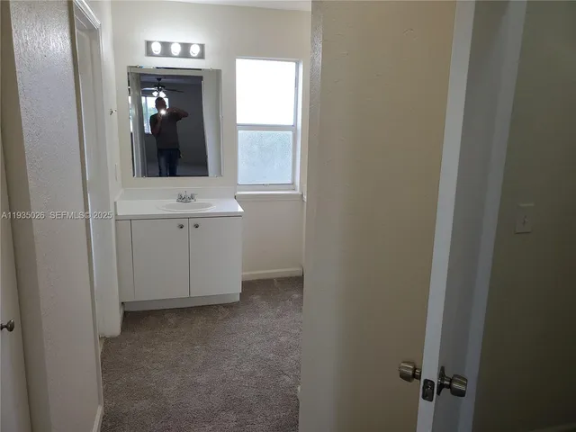 a view of a hallway with wooden floor and cabinet