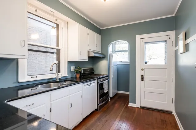 a kitchen with a refrigerator wooden floor and window