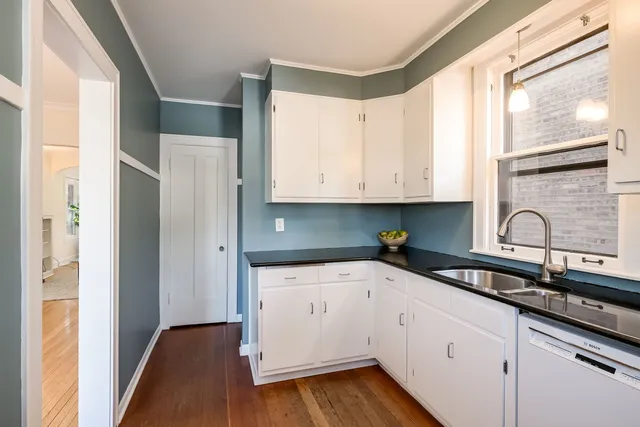 a kitchen with granite countertop white cabinets and white appliances