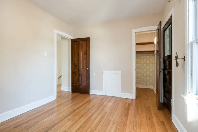an empty room with wooden floor and a window