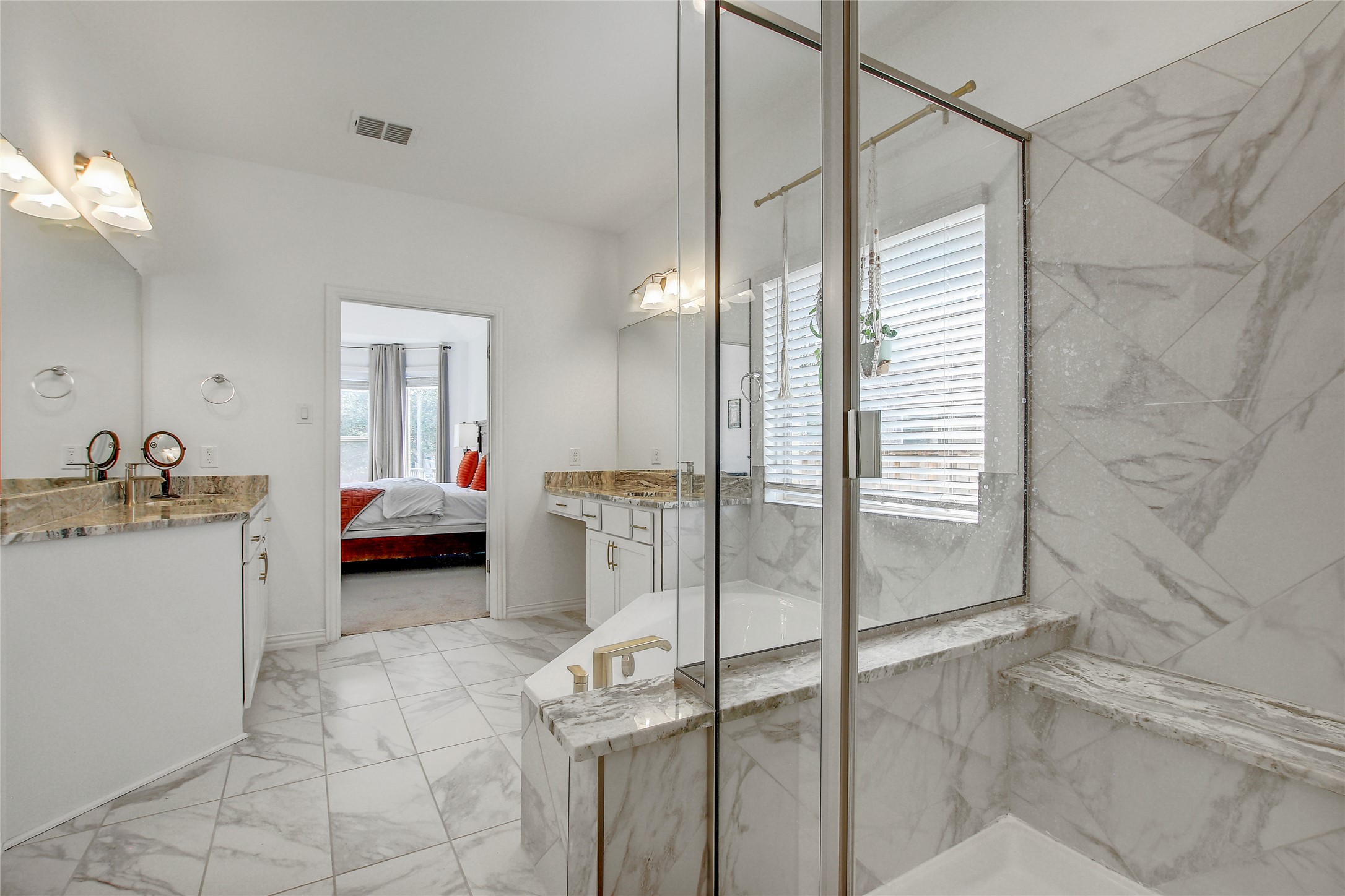 104 Millbend Road Georgetown, TX 78633 - Photo 22 of 40 Marble-clad primary bathroom with dual vanities and a glass-enclosed shower and tub.