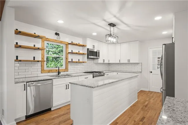a kitchen with a stove a sink a center island and cabinets