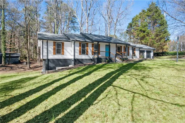 a view of a house with a yard patio and fire pit