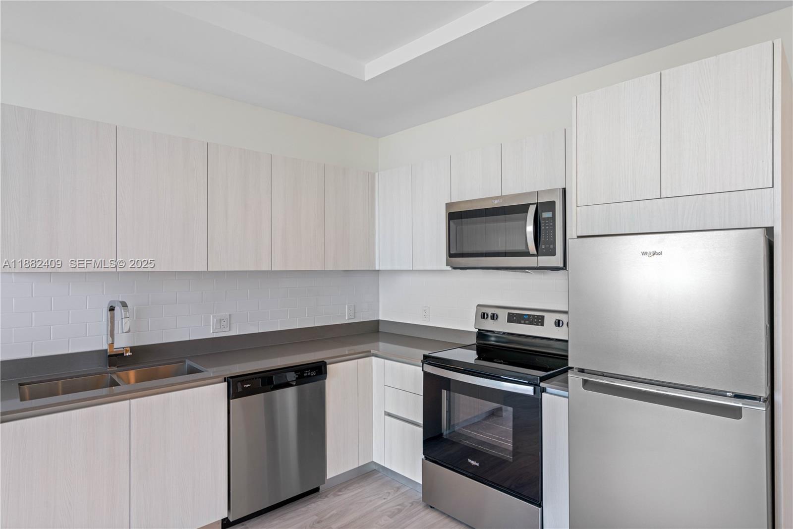 1809 Jackson Street, Unit 709 Hollywood, FL 33020 - Photo 26 of 40 a kitchen with granite countertop white cabinets and stainless steel appliances
