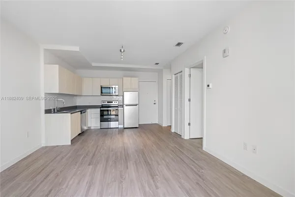 a kitchen with stainless steel appliances granite countertop a sink and wooden floors