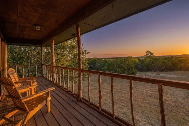 a view of a balcony with wooden floor and outdoor seating