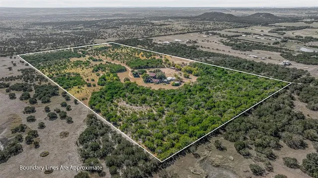 an aerial view of a residential houses with a yard and ocean view