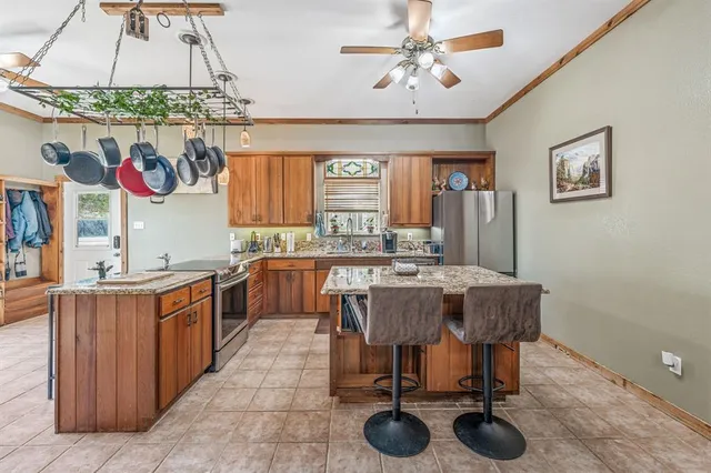 a dining room with stainless steel appliances a table and chairs