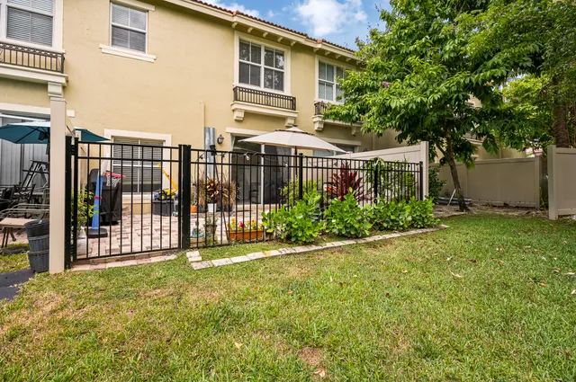 a view of a house with a small yard and wooden fence