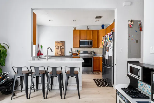 a kitchen with stainless steel appliances a stove a sink dishwasher and a refrigerator