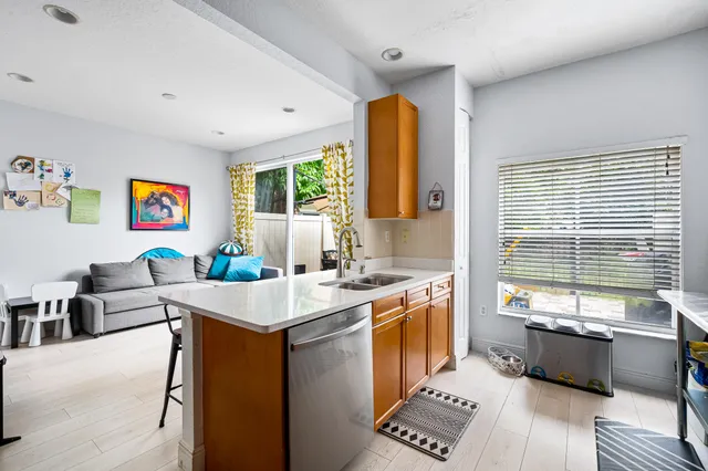 a view of kitchen with stainless steel appliances granite countertop sink stove top oven and cabinets