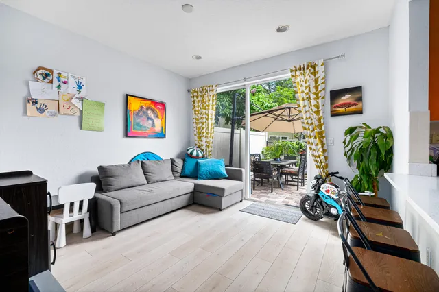 a living room with furniture a flat screen tv and a potted plant