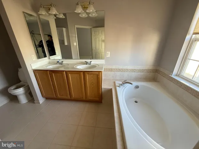 a bathroom with a tub sink and mirror