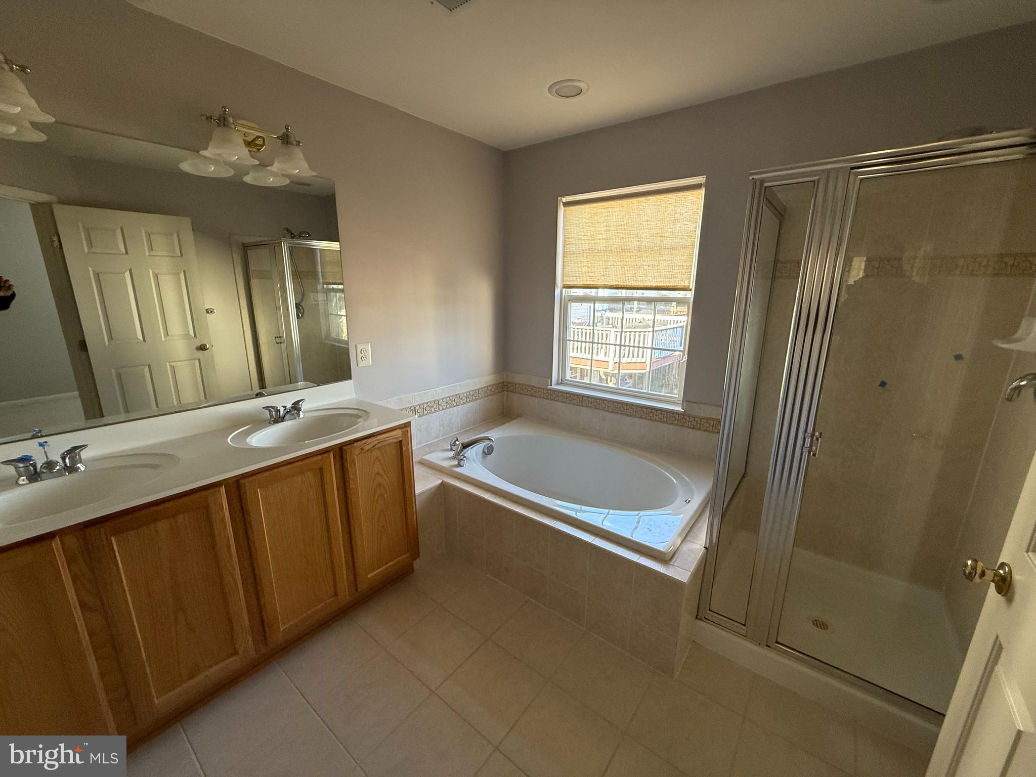 7088 Maiden Point Place, Unit 25 Elkridge, MD 21075 - Photo 9 of 16 a bathroom with a tub a double vanity sink and mirror