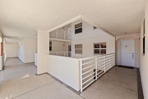 a front view of multi story residential apartment building with yard and parking space