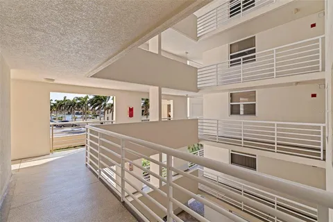 a front view of multi story residential apartment building with yard and sign board