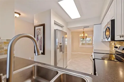 an empty room with chandelier fan and windows