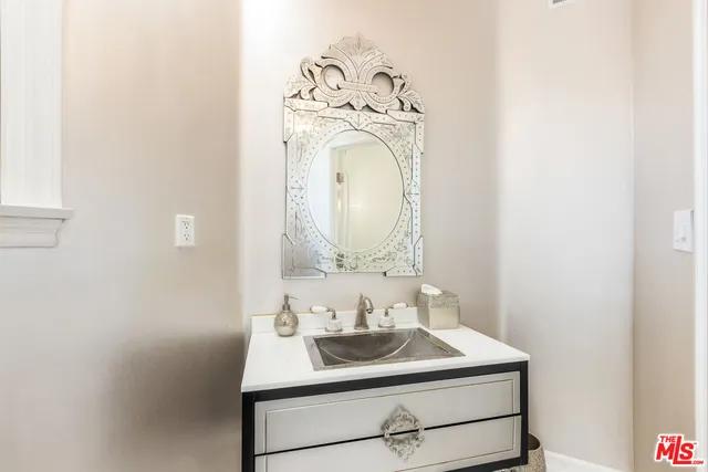 a bathroom with a granite countertop shower sink and mirror
