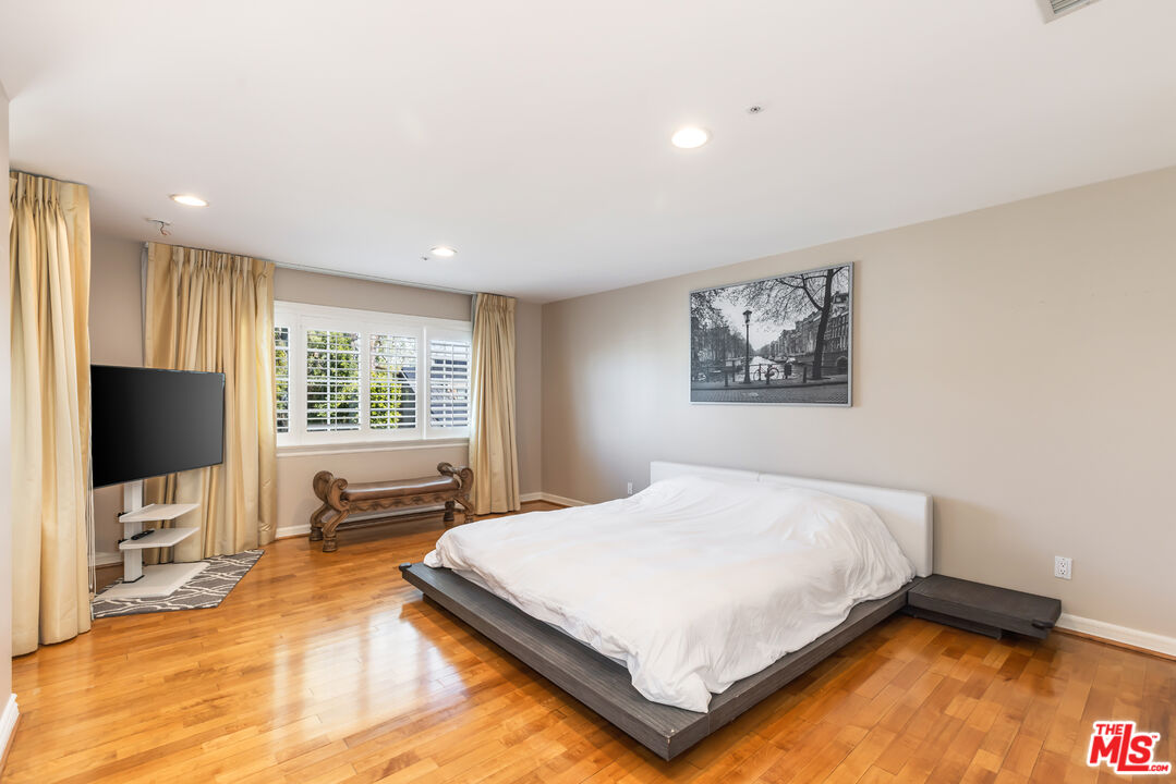 1957 Linda Flora Drive Los Angeles, CA 90077 - Photo 29 of 48 a bedroom with a bed flat screen tv and windows
