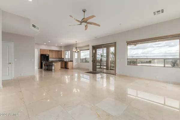 a view of a dining room and livingroom with furniture wooden floor a chandelier