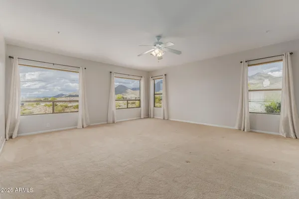 an empty room with an entryway and kitchen view