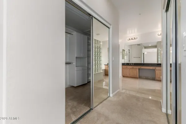an empty room with windows and chandelier fan