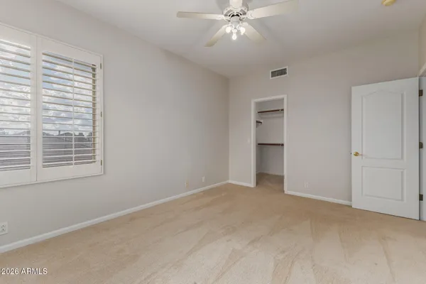 an empty room with a window and a fan