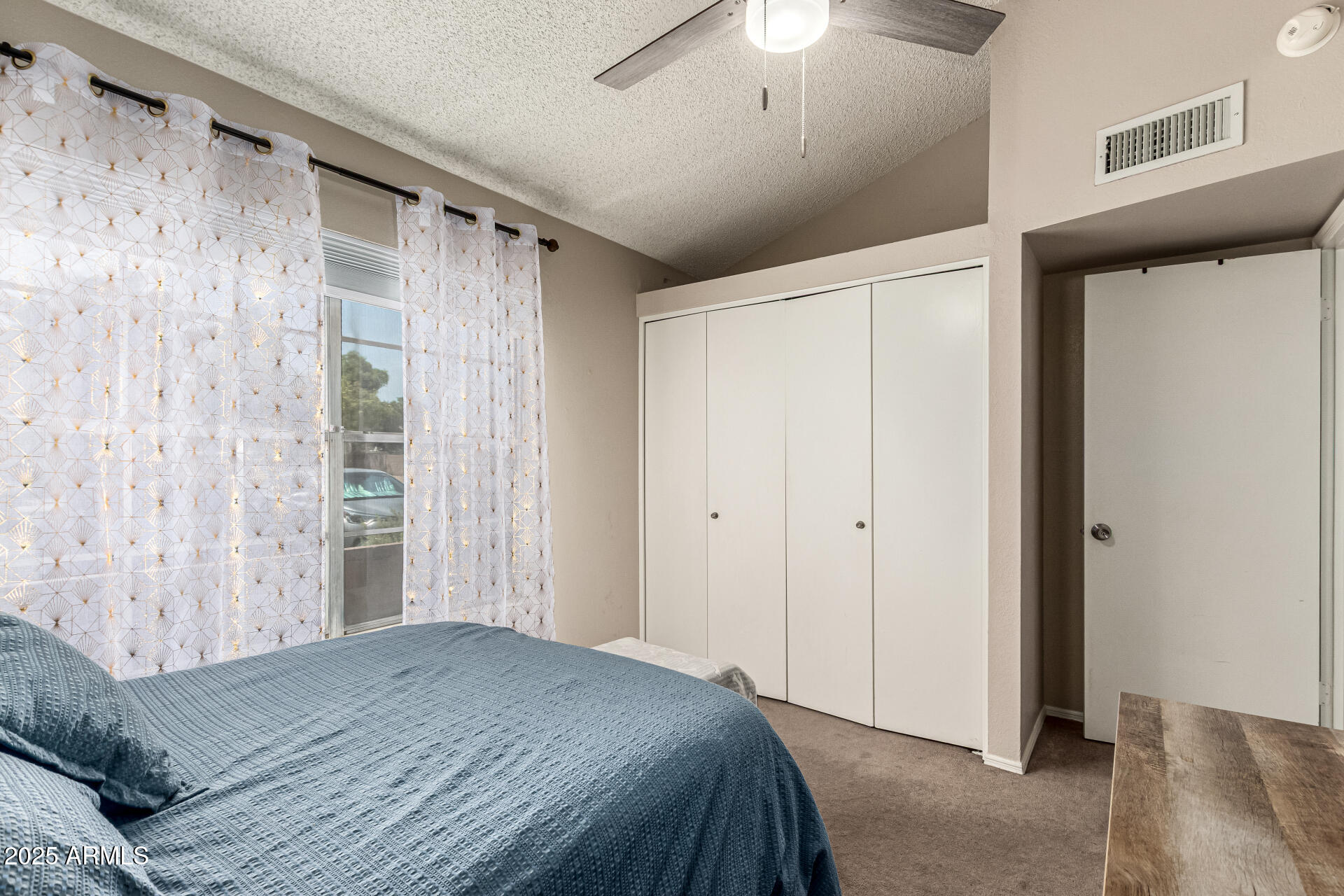 8111 West Wacker Road, Unit 1 Peoria, AZ 85381 - Photo 17 of 26 a bedroom with a large bed and a chandelier fan