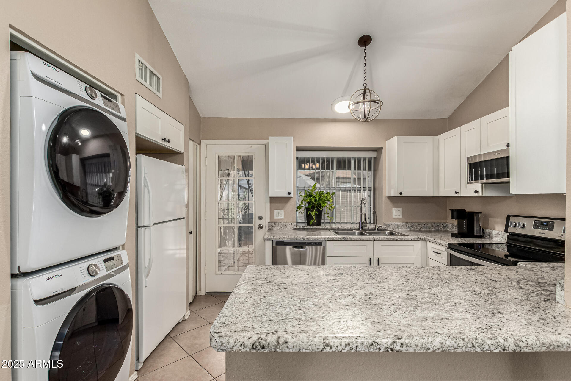 8111 West Wacker Road, Unit 1 Peoria, AZ 85381 - Photo 21 of 26 a kitchen with stainless steel appliances granite countertop a sink a stove top oven a counter space and cabinets