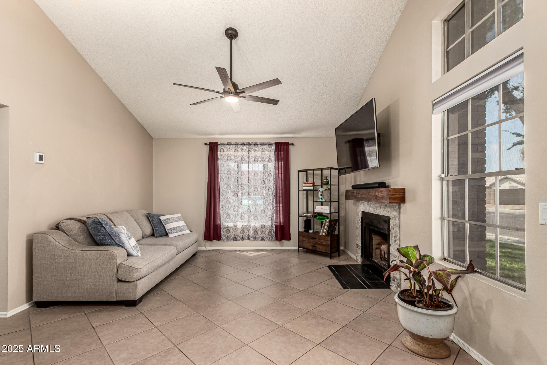 8111 West Wacker Road, Unit 1 Peoria, AZ 85381 - Photo 10 of 26 a living room with furniture a fireplace and a flat screen tv