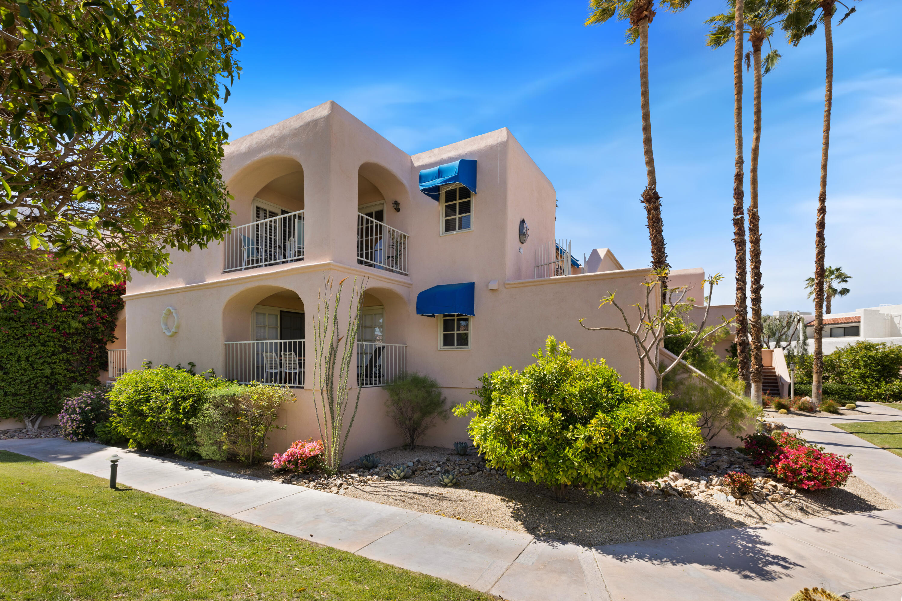 500 East Amado Road, Unit 613 Palm Springs, CA 92262 - Photo 3 of 28 a front view of a house with a yard