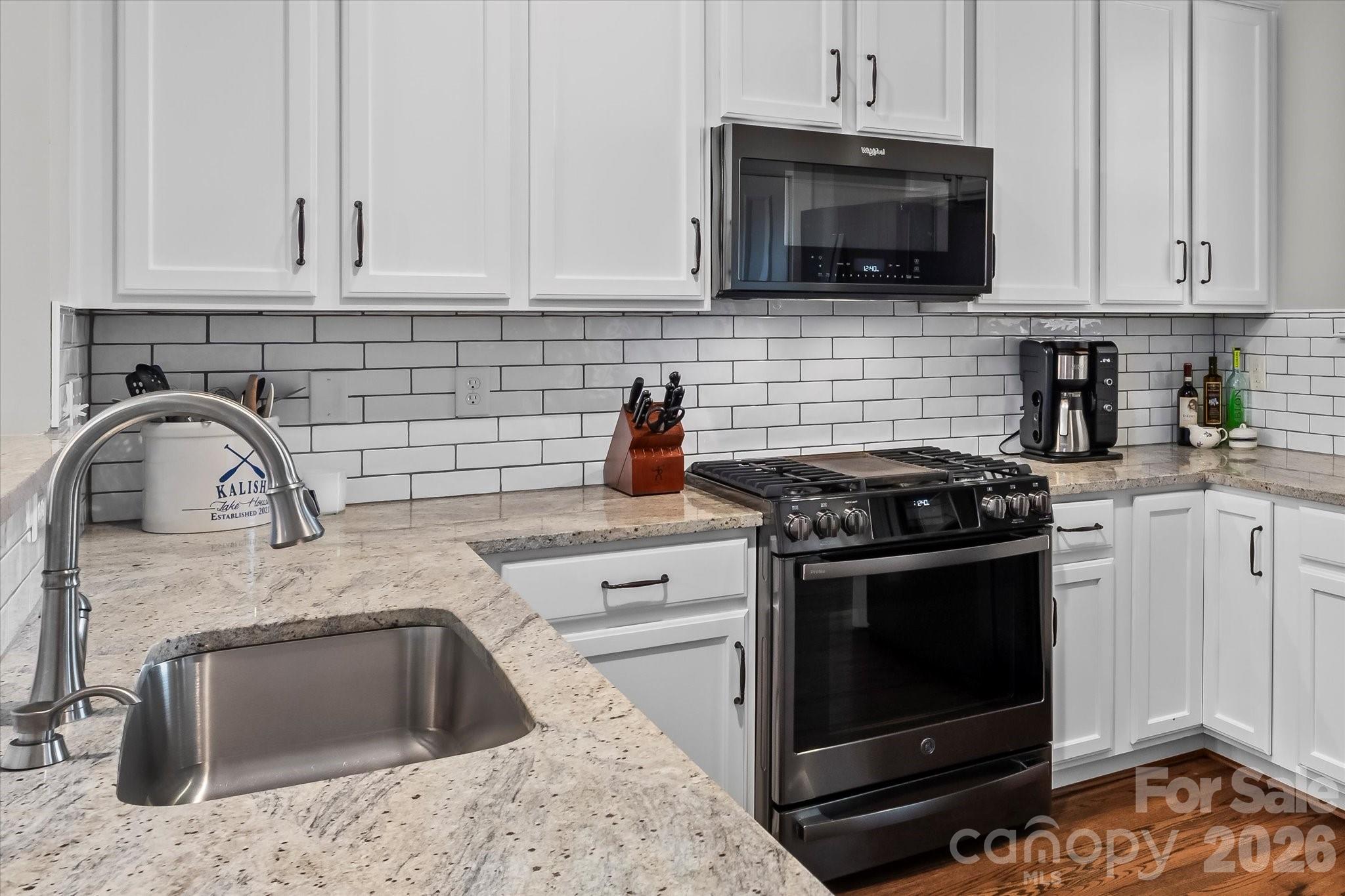 301 Bridges Farm Road Mooresville, NC 28115 - Photo 17 of 46 a kitchen with granite countertop a stove top oven microwave and cabinets