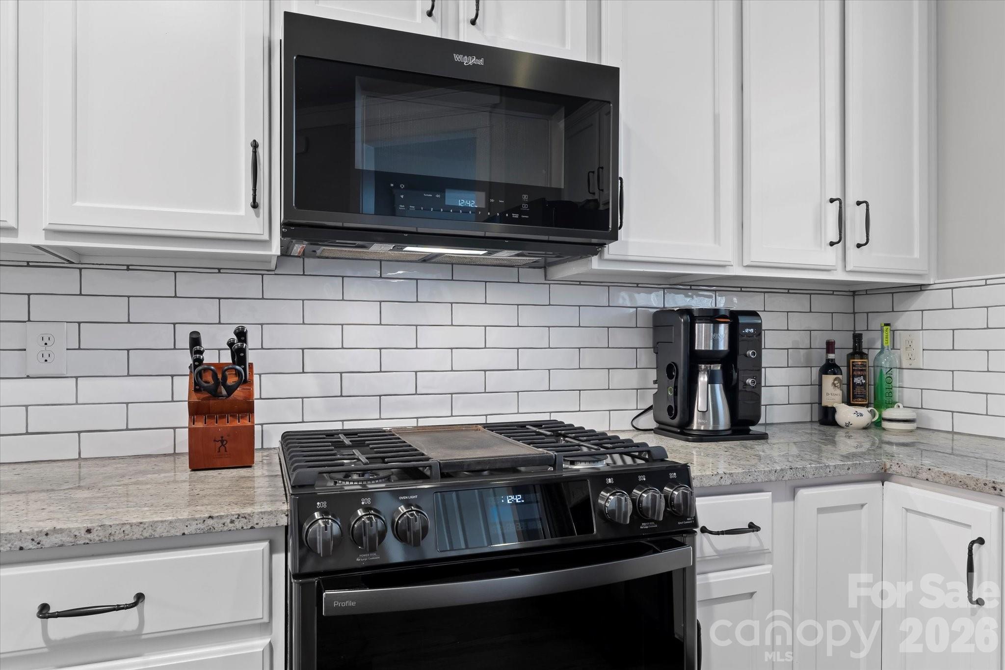 301 Bridges Farm Road Mooresville, NC 28115 - Photo 18 of 46 a kitchen with stainless steel appliances granite countertop white cabinets and stove