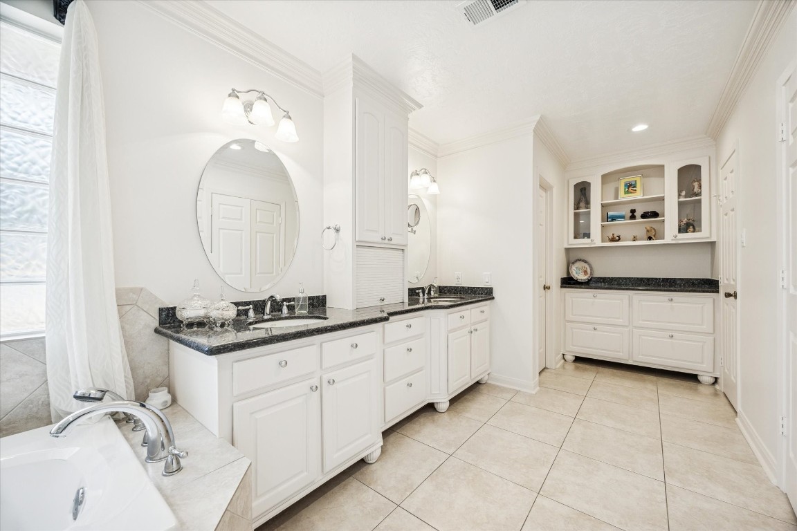 1502 Adkins Road Houston, TX 77055 - Photo 18 of 35 a bathroom with a granite countertop double vanity sink a mirror and bathtub