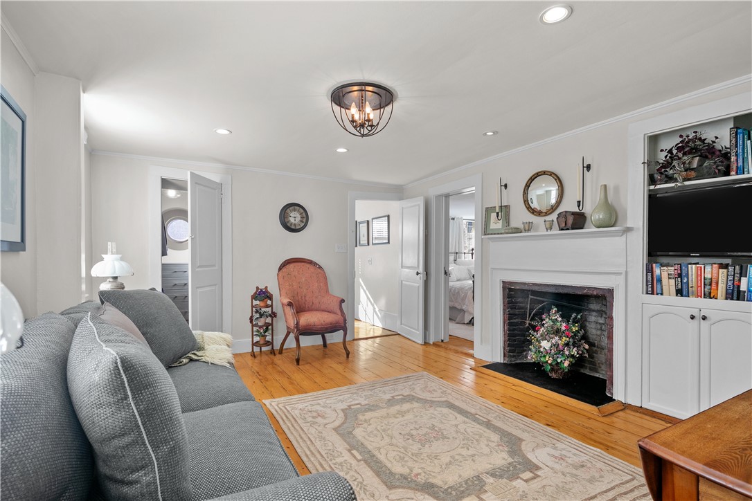 70 Mill Street Newport, RI 02840 - Photo 23 of 50 Den with wood burning fireplace and built-in cabinet with television. One of two walk-in closets is pictured.