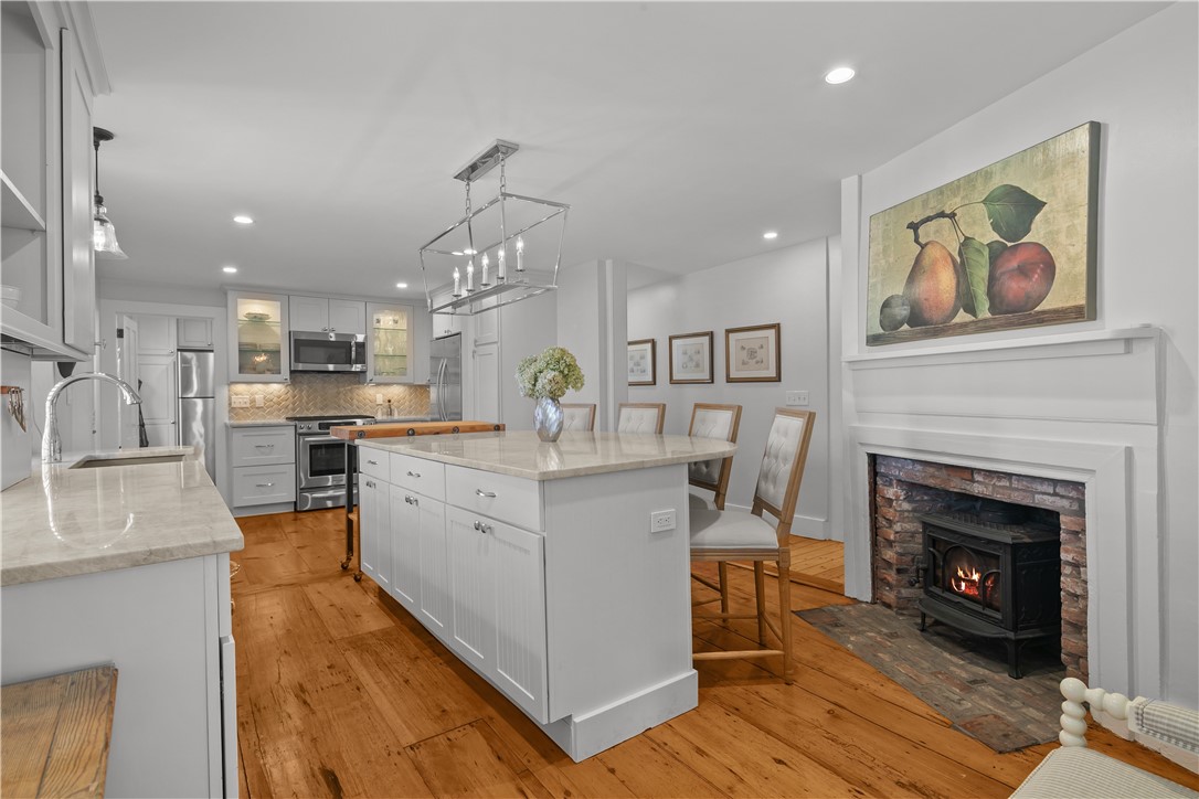 70 Mill Street Newport, RI 02840 - Photo 4 of 50 Cook's kitchen features lovely pine floors, large island, wood burning stove and stainless-steel appliances.