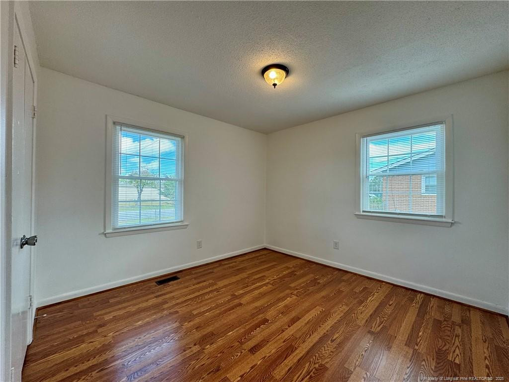 703 Odell Road Spring Lake, NC 28390 - Photo 13 of 21 an empty room with wooden floor and windows