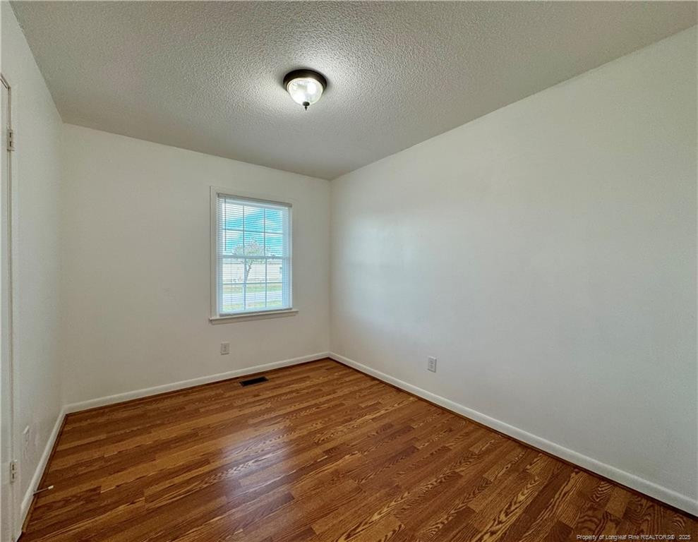 703 Odell Road Spring Lake, NC 28390 - Photo 16 of 21 an empty room with wooden floor and windows