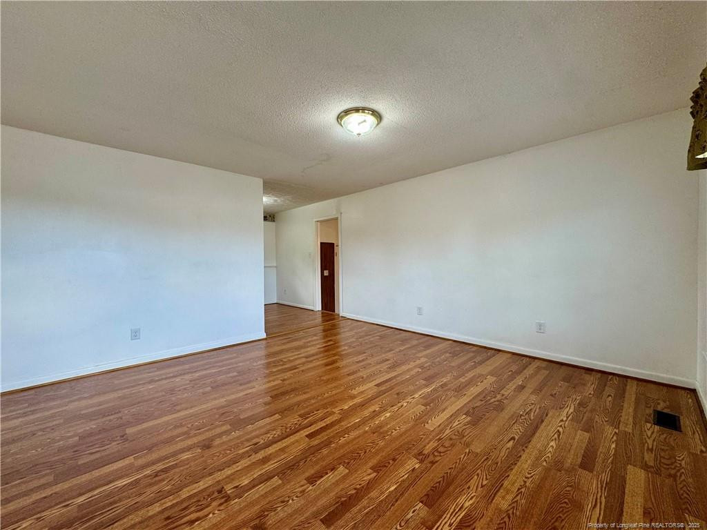 703 Odell Road Spring Lake, NC 28390 - Photo 2 of 21 a view of an empty room with wooden floor and a window