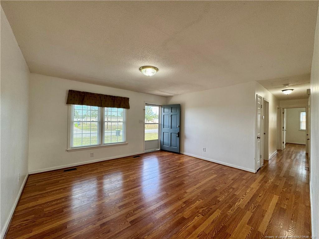 703 Odell Road Spring Lake, NC 28390 - Photo 4 of 21 a view of an empty room with wooden floor and a window