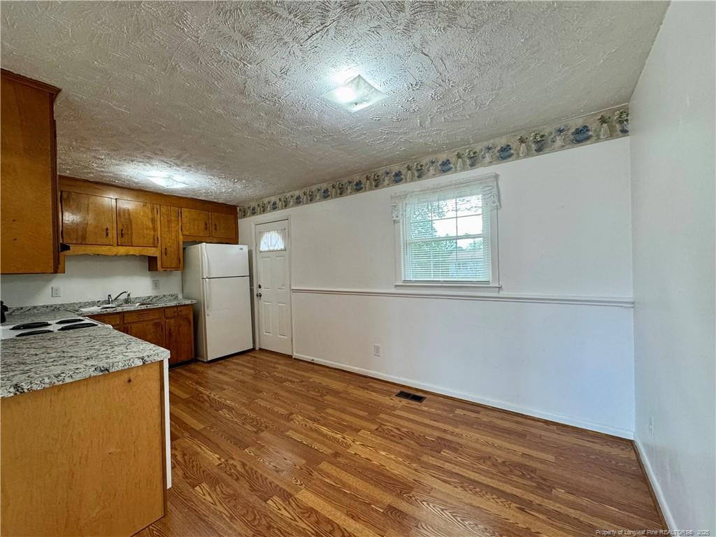 703 Odell Road Spring Lake, NC 28390 - Photo 5 of 21 a view of a kitchen with a sink and a refrigerator