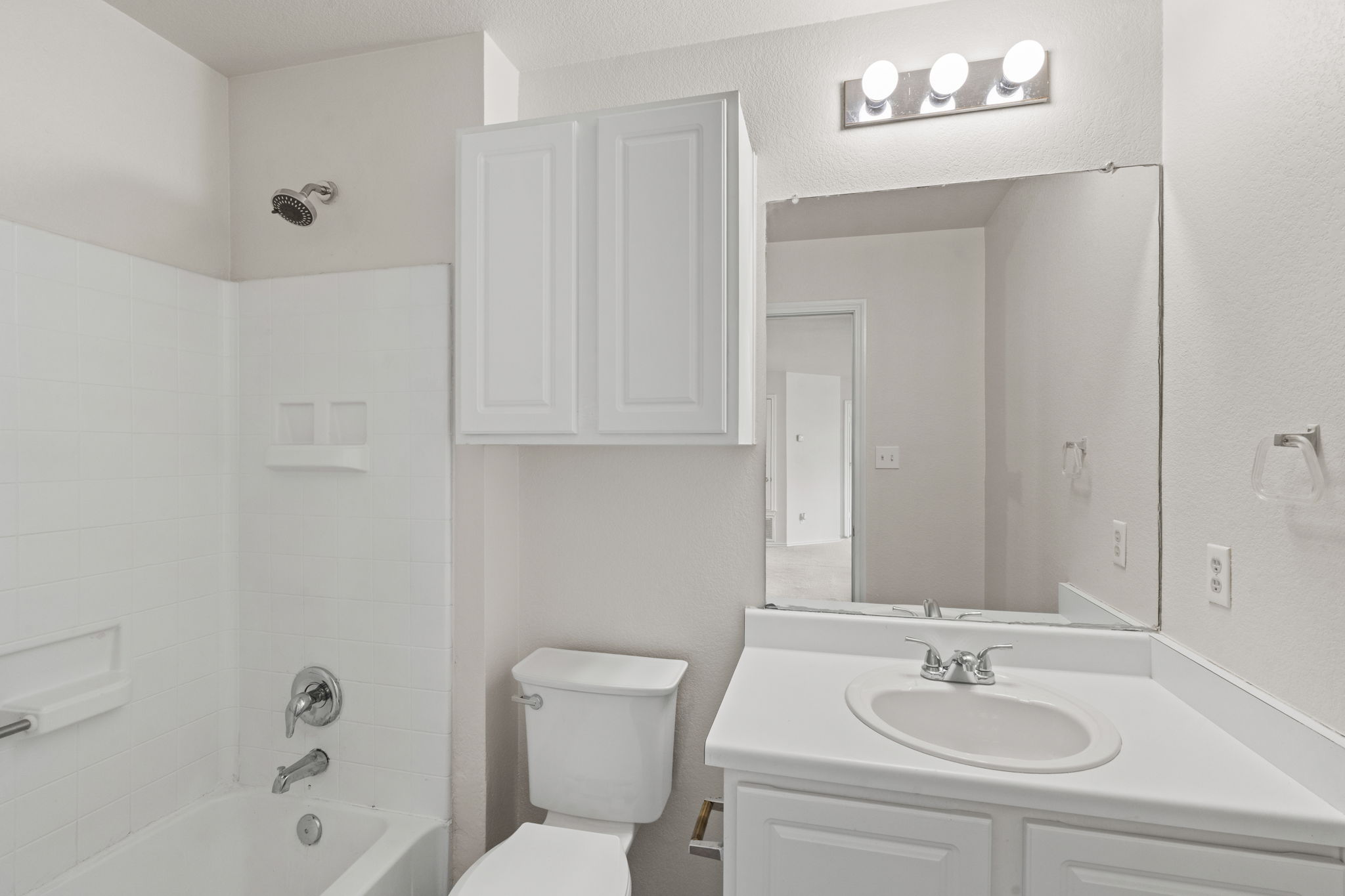 208 Dandelion Loop Kyle, TX 78640 - Photo 29 of 39 Secondary full bathroom on second level features a white vanity with an integrated sink and chrome fixtures, a shower/tub combination with a chrome showerhead, and wall-mounted storage cabinetry